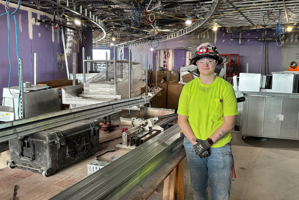Erin standing in front of the bending machine.